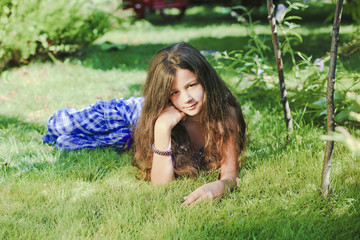 Naklejka na ściany i meble Beautiful young fashion model in swimsuit posing on the green grass
