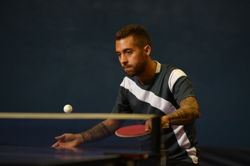 jeune homme pratiquant le tennis de table
