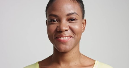 Portrait of a smiling happy attractive young black model with beautiful skin isolated on white