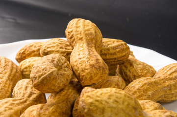 Peanuts in shell on dark background, close up