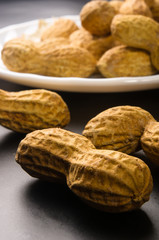 Peanuts in shell on dark background, close up