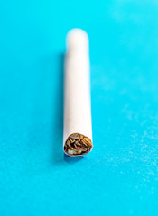 Cigarette on a blue background. Close up.