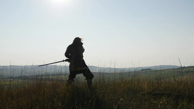 Silhouette of a Viking practicing using the sword for battle.