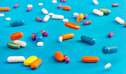 Tablets fall on a blue background. Medical background.