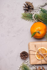 Christmas presents and oranges on grey stone background