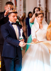 Religious couple with crowns on the head go to church