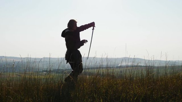 Silhouette of a Viking practicing using the sword for battle.