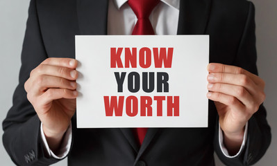 Businessman holding a card with text Know Your Worth