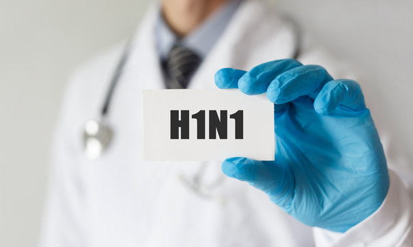 Doctor holding a card with text H1N1, medical concept