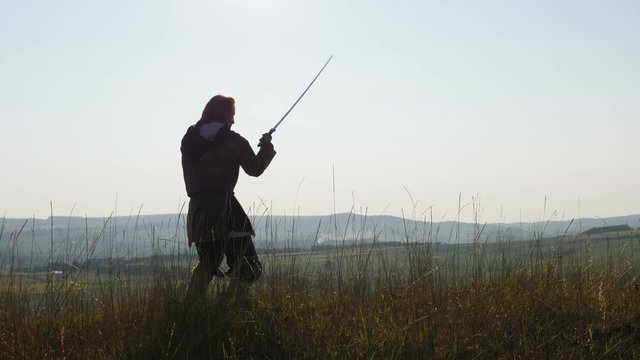 Silhouette of a Viking practicing using the sword for battle.