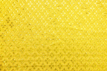 Fabric gold background or texture. Gold textile or silk.