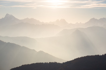 The Alps in soft backlight. Toned mountain range of the Massif des Ecrins National Park, France, arising higher than 4000 m altitude from the alpine arc. Telephoto view at sunset.