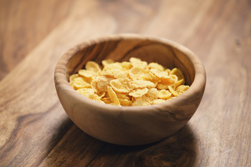 corn flakes in wood bowl closeup