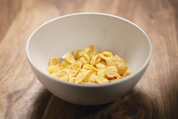 corn flakes in white bowl on table closeup