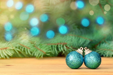 Fir tree branch with Christmas balls on brown wooden background. Top view.