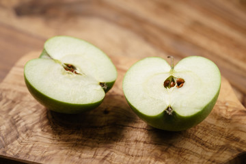 halves of green apple on wood table