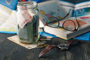 Obraz na płótnie Canvas Travel budget - vacation money savings in a glass jar on world map