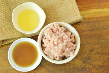 raw minced pork with soy sauce and oil on wooden table