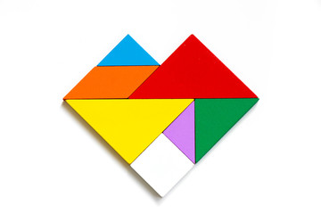 Colorful wood tangram puzzle in heart shape on white background