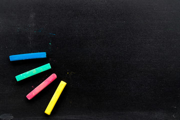 Blank black board with red, green, blue, yellow color chalk background with copy space