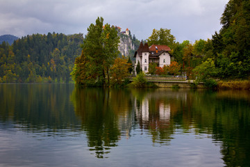 Fototapeta premium A manor in Lake Bled shore with autumn colors and reflection