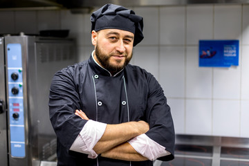 Chef in the kitchen.black uniform. to fold one's arms