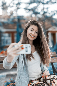 beautiful teenage girl making selfie in the park,