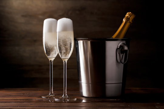 Photo of two glasses with sparkling wine, iron bucket