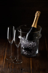 Wine glasses on wooden table with pail with ice