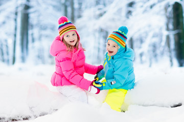 Kids playing in snow. Children play outdoors in winter snowfall.