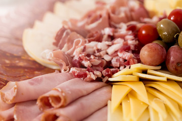 Tray with bacon, cheese cubes, salami, ham  decorated with grapes © Deymos.HR