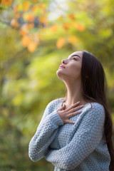 Young model, woman, girl with brunette hair, red lips and beautiful eyes look up to the sky on green background