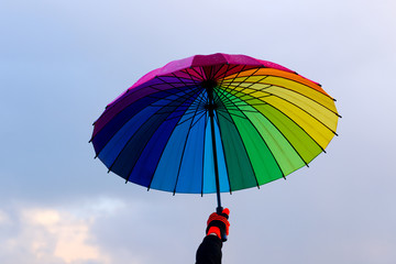 Umbrella in hand against sky background