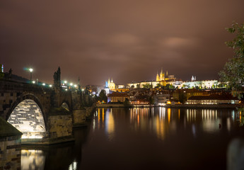 Fototapeta na wymiar Prague Castle and Charles Bridge in Prague, Czech Republic. Light of lanterns reflected in the river Vltava.