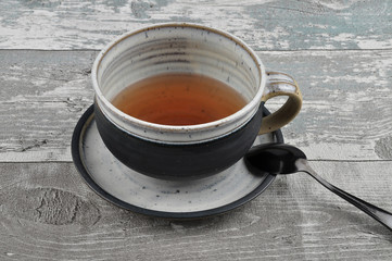 Tasse Tee auf verwittertem Holz