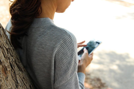 A woman holding a phone in the park