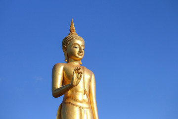 Gold Buddha statue with the sky in the background