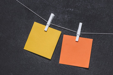 Bright colored stickers on a rope on a dark background with free copy space