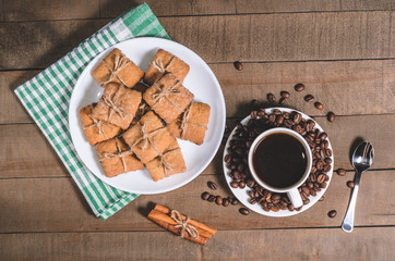 Black coffee in a white cup on a green napkin and homemade cookies.