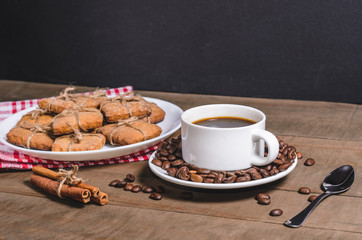 Black coffee in a white cup on a red napkin and homemade cookies.