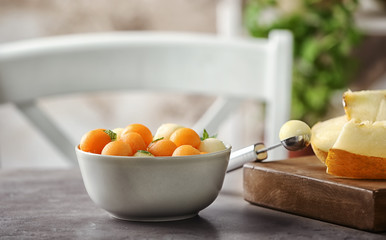 Bowl with fresh melon balls on table