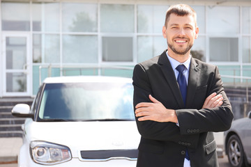 Salesman standing near new car outdoors