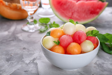 Bowl with fresh fruit balls on table