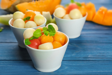 Bowls with fresh fruit balls on table