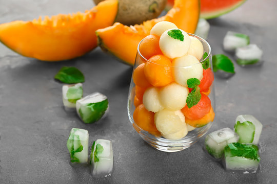 Glass with fresh fruit balls on table