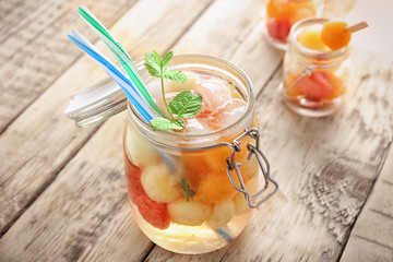 Jar of delicious cocktail with melon balls on table