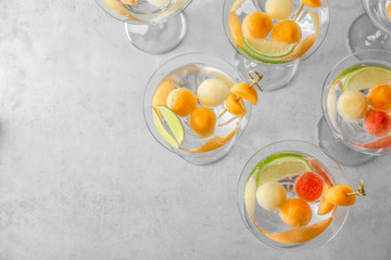 Glasses of delicious cocktails with melon balls on table