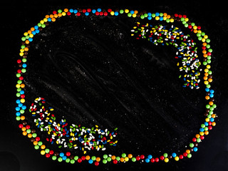 Sunflower seeds frame. Sweets in color glaze. Black background