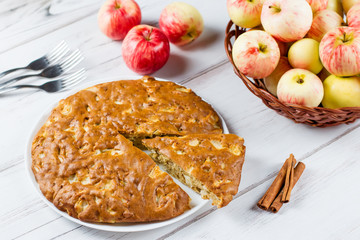 Homemade apple pie with cinnamon and fresh ripe apples in the background