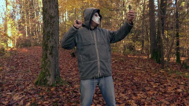 Man with scary Halloween mask take selfies on phone